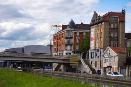 Photo for Reims, France - May 2021 - Brick apartment buildings on the pier of Paul Doumer Boulevard, and the Pont de Vesle Bridge crossing the Canal from Aisne to Marne - Royalty Free Image