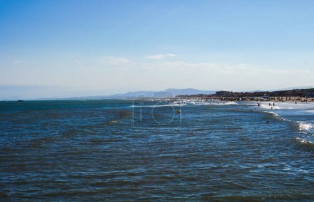 Téléchargez les photos : Vagues sur les eaux bleu profond de la mer Méditerranée, vues de la plage de Narbonne-Plage, une station balnéaire dans le sud de la France ; à l'horizon, la crête des Pyrnes est visible - en image libre de droit