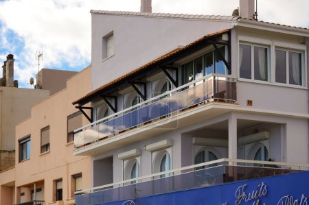 Téléchargez les photos : Valras-Plage, France - oct. 2021- Une villa typique de style sud, dotée de balcons avec balustrade en verre et auvent carrelé, abritant un restaurant au niveau de la rue et un hébergement touristique aux étages supérieurs - en image libre de droit