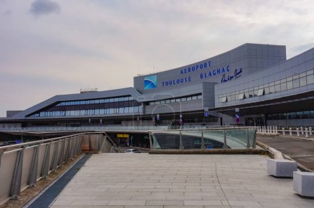 Téléchargez les photos : Toulouse, France - Octobre 2020 - Bâtiment principal de l'aéroport international Toulouse-Blagnac, doté d'une passerelle en verre surélevée pour les taxis desservant la voie de débarquement et d'une façade en béton avec baies vitrées - en image libre de droit
