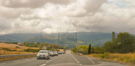 Foto de Castres, sur de Francia - ago. 2020 - Una línea de coches en la carretera nacional N112, que se dirige hacia las hermosas tierras altas nubladas del Montagne Noire ("Montaña Negra"), una zona rural tranquila - Imagen libre de derechos