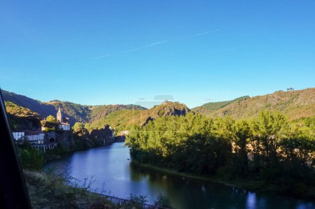Foto de Hermoso paisaje de montaña en Ambialet, al sur de Francia, un pintoresco pueblo construido en una península boscosa en el valle del río Tarn, dominado por el priorato medieval en la cima de un afloramiento rocoso - Imagen libre de derechos