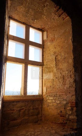 Foto de Dentro de las ruinas del castillo de Castelnau-de-Lvis, al sur de Francia: ventanal medieval en la sala principal abovedada de la casa señorial - Imagen libre de derechos
