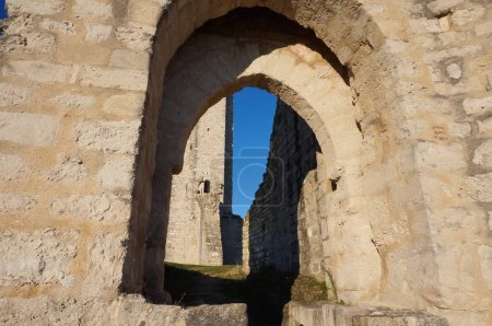 Téléchargez les photos : Restes d'une porte fortifiée voûtée massive dans le château médiéval de Castelnau-de-Levis, France, un ancien bastion construit en calcaire sur une colline, avec la tour de guet en arrière-plan - en image libre de droit
