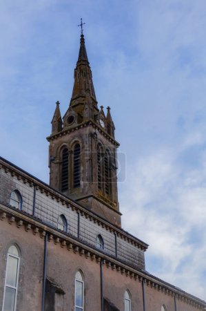 Téléchargez les photos : Clocher de l'église néogothique de Villefranche d'Albigeois, un village du sud de la France ; le clocher dispose d'une horloge et de fenêtres voûtées avec des louvres pour refléter le son de la cloche - en image libre de droit