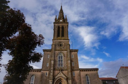 Téléchargez les photos : Devant l'église néogothique de Villefranche d'Albigeois, un village du sud de la France ; le bâtiment religieux comporte une rosette, des vitraux et un clocher surmonté d'une croix - en image libre de droit