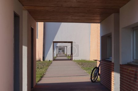 Téléchargez les photos : Albi, France - Février 2022 - Vue en perspective, avec l'alignement des portes des résidences étudiantes, sur la passerelle qui traverse le campus d'IMT Mines Albi, une école de génie française - en image libre de droit