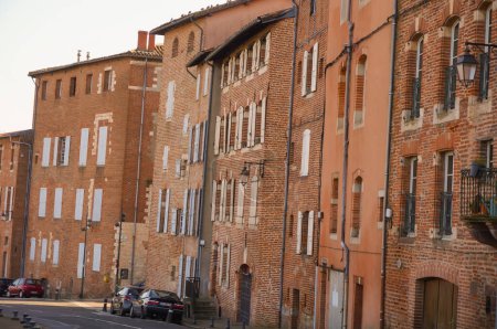 Téléchargez les photos : Anciennes maisons de ville traditionnelles en brique construites sur le remblai, dans la ville historique d'Albi, dans le sud de la France, surplombant le Tarn - en image libre de droit
