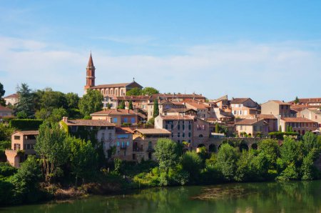 Photo for Albi, France - Aug. 2021 - Traditional brick townhouses on the Right Bank of the River Tarn : the quarter, seen from the Berbie Gardens, is dominated by the belfry of Sainte-Madeleine's church - Royalty Free Image