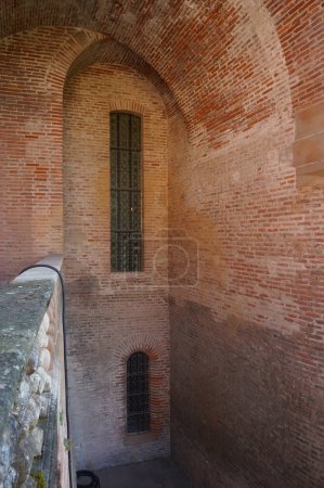 Foto de Albi, Francia - agosto de 2021 - Una vidriera en un hueco de la muralla creada por dos bóvedas de ladrillo, en el Palacio del Berbie, un castillo medieval y la residencia de un antiguo obispo, ahora un museo - Imagen libre de derechos