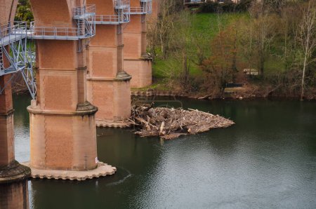 Foto de Marco metálico que sobresale sobre el agua del río Tarn, en el sitio de construcción de la futura pasarela de Albi, Francia, construida bajo los arcos de un viaducto ferroviario más antiguo, en enero de 2021. - Imagen libre de derechos