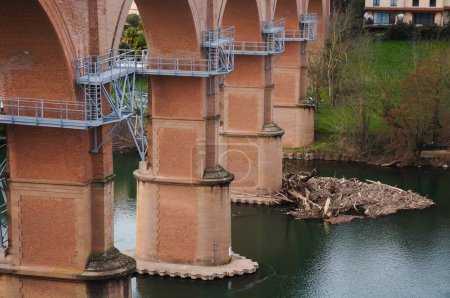 Photo for Metal framework overhanging above the water of the River Tarn, at the construction site of the future gangway of Albi, France, built under the arches of an older railway viaduct, in Jan. 2021 - Royalty Free Image