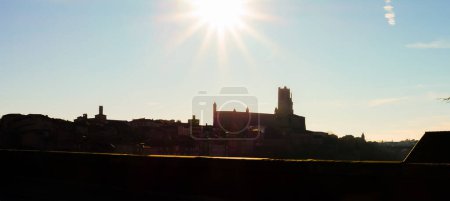 Téléchargez les photos : Lumière du soleil d'été aveuglante au-dessus de la ville épiscopale d'Albi, France, site du patrimoine mondial de l'UNESCO dominé par la silhouette de la cathédrale médiévale en brique de Sainte-Ccile, vue contre la lumière - en image libre de droit