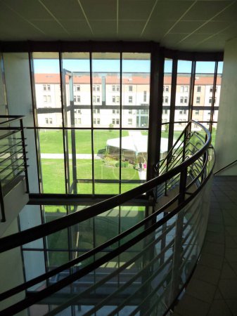 Téléchargez les photos : Albi, France - Juillet 2015 - Escalier et mezzanine à l'intérieur de l'Institut universitaire national Jean-Franois Champollion, et baies vitrées donnant sur le campus et ses espaces verts - en image libre de droit
