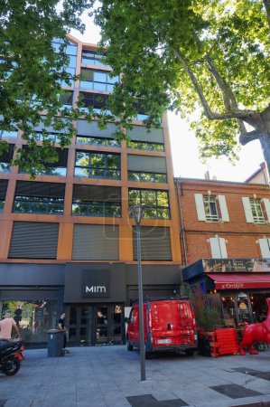Téléchargez les photos : Albi, France - Août 2020 - Bâtiment commercial à plusieurs étages dans la rue commerçante ombragée par les arbres du boulevard Strasbourg, dans le centre-ville, abritant un magasin de vêtements de la marque de prêt-à-porter Mim - en image libre de droit