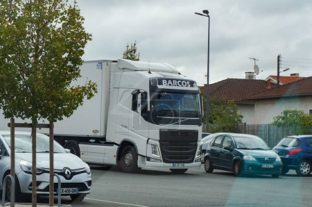 Foto de Albi, Francia - Sept. 2020 - Un camión de reparto blanco (un semirremolque del fabricante sueco Volvo Trucks), operado por un transportista de motor, garantiza el suministro de una tienda minorista Lidle por la mañana - Imagen libre de derechos