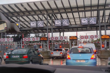 Foto de Lyon, Francia - Junio 2018 - Coches que pagan en una puerta de peaje con señales luminosas y señales de tráfico en la carretera de circunvalación - Imagen libre de derechos