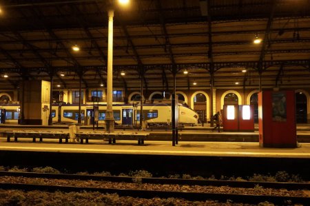 Photo for Toulouse, France - Jan. 2020 - Night shot of the tracks and platforms of Toulouse-Matabiau train station, with an Alstom RGIOLIS railcar operated by SNCF on the TER (Regional Express Train) network - Royalty Free Image