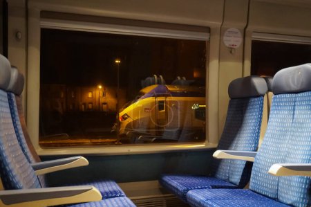 Foto de Lugar desconocido, Francia - enero de 2021 - Asientos en segunda clase dentro de un Bombardier TER (Regional Express Train), junto a una ventana, desde la que otro tren, un Rgiolis TER - Imagen libre de derechos