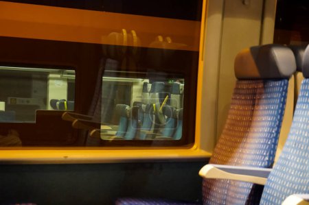 Foto de Lugar desconocido, Francia - enero de 2021 - Asientos en segunda clase dentro de un Bombardier TER (Regional Express Train), junto a una ventana, desde la que otro tren, un Rgiolis TER - Imagen libre de derechos