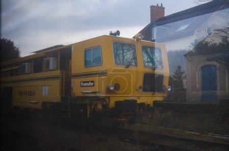 Photo for Saint-Amand-Montrond, France - Feb. 2022 - A yellow, old locomotive of a special train made by the French manufacturer Framafer, for the construction or maintenance of railroads, at a station platform - Royalty Free Image