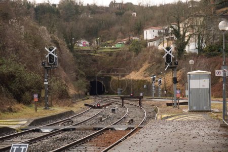 Foto de Figeac, Francia - Feb. 2022 - Pistas, incluyendo vías sin salida con topes, señalización luminosa y túnel en la montaña, en la estación de tren de Figeac, un pueblo rural en el macizo central - Imagen libre de derechos