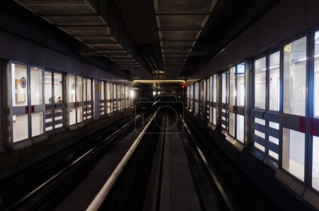 Foto de Toulouse, Francia - Junio 2019 - Perspectiva de una galería del metro automatizado de Toulouse en la estación de metro de Argoulets, con puertas de pantalla de plataforma a ambos lados y doble vía férrea - Imagen libre de derechos