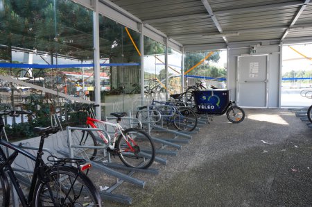 Téléchargez les photos : Toulouse, France - 4 juin 2023 - Parking fermé pour vélos, avec toit, parois vitrées et crémaillères pour verrouiller les vélos, dans le hub multimodal de l'UT3, qui dispose également de stations de bus, métro, sky et parkings - en image libre de droit