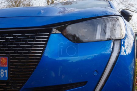 Foto de Graulhet, Francia - Dic. 2021 - Detalle de la rejilla del radiador y logotipo de una Peugeot 208 II GT Line azul, la versión deportiva de la 208, un modelo producido por el fabricante francés PSA Peugeot-Citron - Imagen libre de derechos