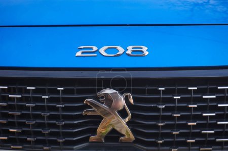 Téléchargez les photos : Graulhet, France - Décembre 2021 - Détail de la calandre et du logo d'une Peugeot 208 II GT Line bleue, la version sportive de la 208, un modèle produit par le fabricant français PSA Peugeot-Citron - en image libre de droit