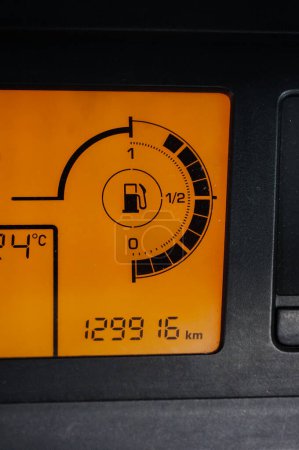 Téléchargez les photos : Détail du tableau de bord numérique d'une voiture conçue en France, avec un écran monochromatique affichant une jauge de gaz sous la forme d'un cadran, avec une icône de station pétrolière et un odomètre en kilomètres - en image libre de droit