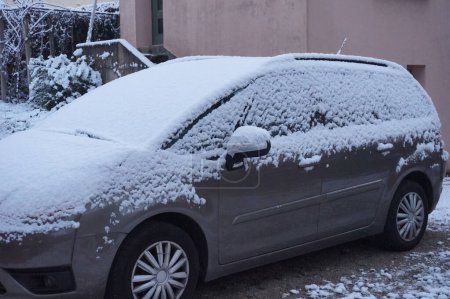 Téléchargez les photos : Tarn, France - Janv. 2021 - Un paysage hivernal typique : le pare-brise, le capot, le toit et les fenêtres d'une voiture garée dans un jardin, dans le sud de la France, sont recouverts d'une fine couche de neige poudreuse - en image libre de droit