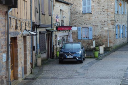 Photo for Najac, France - Dec. 2019 - Renault Espace V Initiale Paris, a mid-size luxury crossover by French manufacturer Renault, parked at the foot of traditional ancient stone houses in a cobbled street - Royalty Free Image