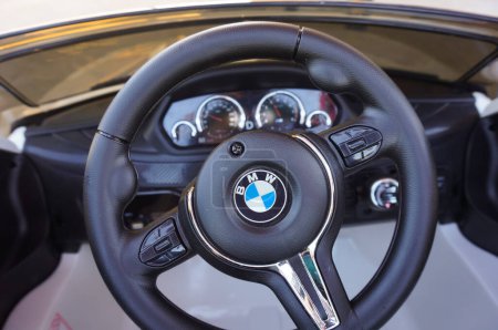 Téléchargez les photos : Toulouse, France - Août 2019 - Volant chromé et tableau de bord dans le flou d'une voiture jouet pour enfant reproduisant une BMW X6, un VUS de luxe produit par le constructeur allemand BMW à Spartanburg, USA - en image libre de droit