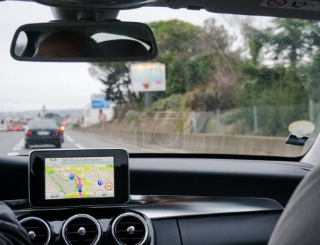 Téléchargez les photos : Être sur la route avec l'itinéraire affiché sur l'écran du GPS de la voiture, sur la console centrale au-dessus des prises d'air rondes du système de climatisation - en image libre de droit