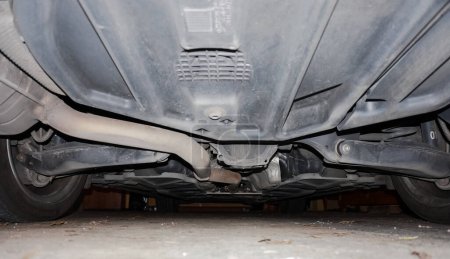 Photo for Bottom view of the underbody of a German diesel executive car showing the exhaust pipe connected with a particulate filter or a catalytic pot and the hanger arms for the suspension of the wheels - Royalty Free Image