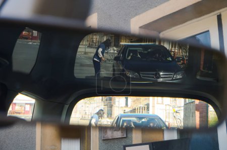 Téléchargez les photos : Tarn, France - Mai 2020 - Phénomène optique surprenant : double image dans le rétroviseur intérieur d'une voiture, à travers le pare-brise arrière, d'une berline Mercedes dans une manœuvre de stationnement dans la rue - en image libre de droit