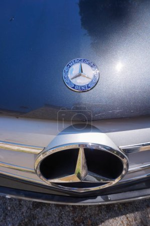 Foto de Tarn, Francia - Mayo 2020 - Vista superior y detalle de la parte delantera de un Mercedes C200 2010, un sedán alemán, con un logotipo estrella en el radiador y uno más pequeño, adornado con ramas de laurel, en la capucha - Imagen libre de derechos