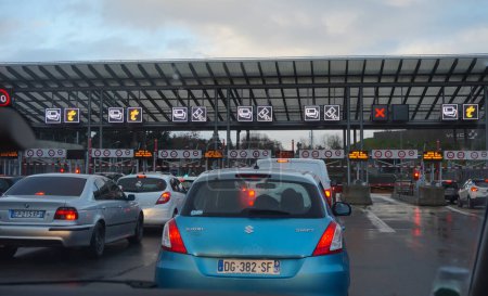 Photo for Yvelines, France - Dec. 2020 - Lines of car waiting to pay the fee, at the toll gate of the Highway Duplex A86, which gives access to the longest tunnel entirely in France, in the region of Paris - Royalty Free Image