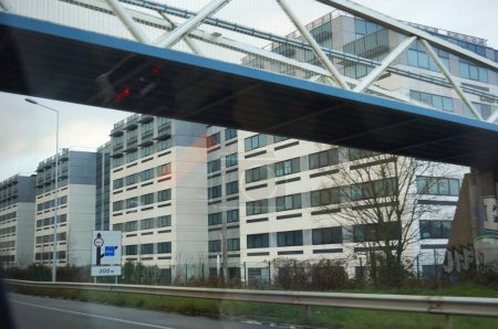 Téléchargez les photos : Yvelines, France - Décembre 2020 - Neo Velizy Estate, un immeuble de bureaux appartenant à BNP Paribas en bordure de l'autoroute A86, dans un parc d'activités à Velizy-Villacoublay, avec un pont traversant la route - en image libre de droit