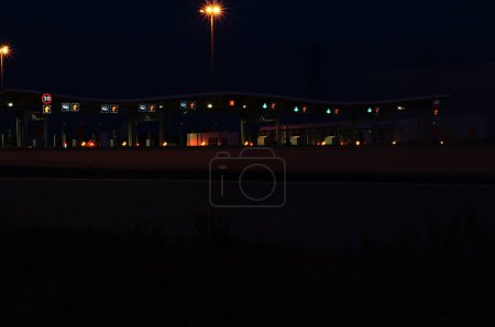 Photo for Saint-Jean-de-Vdas, France - Oct. 2021 - Night shot and silhouette of the toll gate of Page de Montpellier 2, at the end of the highway A709 and at the start of the A9, which goes to Spain - Royalty Free Image
