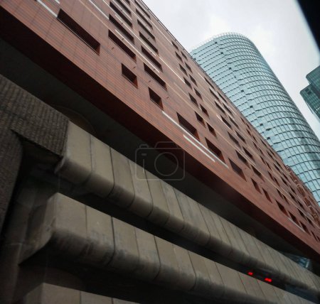 Photo for Paris, France - Dec. 2020 - Low angle view on Ancre Residence apartment building, which is constructed on its above-ground car park and is dominated by the newly-built glass skyscraper Tour Alto - Royalty Free Image