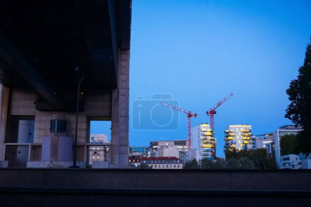 Téléchargez les photos : Paris, France - Sept. 2020 - Bâtiments résidentiels en construction, flanqués de grues à tour, avec reflets de soleil sur la façade, dans le quartier de Bercy, près du ministère des Finances - en image libre de droit