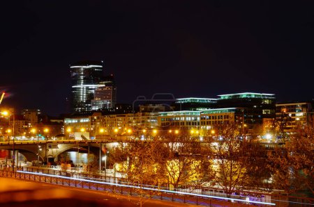 Téléchargez les photos : Paris, France - Avril 2022 - Vue nocturne dans l'obscurité sur le nouveau quartier des affaires de Paris Rive Gauche, dans le 13ème arrondissement, dominé par les tours Duo, avec le pont Tolbiac traversant la Seine - en image libre de droit