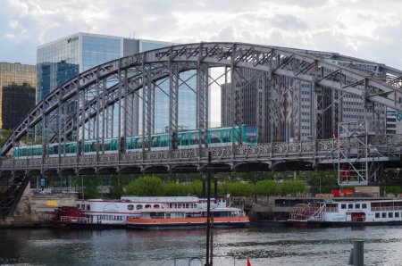 Téléchargez les photos : Paris, France - Mai 2021 - Un train passe sur le viaduc Austerlitz, un pont d'étrave avec pont suspendu construit en 1904, qui supporte un tronçon surélevé de la 5ème ligne de métro, traversant la Seine - en image libre de droit