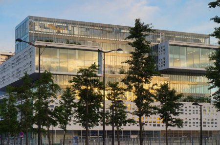 Foto de París, Francia - Junio 2021 - Un edificio de oficinas futurista y moderno al atardecer en la Avenida de Francia, en el distrito financiero de Paris Rive Gauche, con un diseño contemporáneo y geométrico con fachadas de vidrio - Imagen libre de derechos