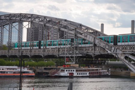 Téléchargez les photos : Paris, France - Mai 2021 - Un train passe sur le viaduc Austerlitz, un pont d'étrave avec pont suspendu construit en 1904, qui supporte un tronçon surélevé de la 5ème ligne de métro, traversant la Seine - en image libre de droit