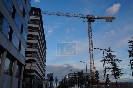 Foto de París, Francia - Junio 2021 - Una vista por la noche en la Avenida de Francia, una de las principales calles del distrito de negocios de Paris-Rive Gauche (distrito 13), con una grúa torre en una obra de construcción - Imagen libre de derechos