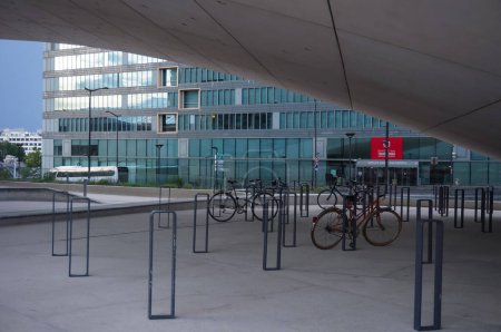 Foto de París, Francia - junio 2021 - Aparcamiento para bicicletas con cierres en forma de anillo bajo el arco de la sede del Grupo Le Monde, en la avenida Pierre Mendes-France, en el distrito financiero de Paris Rive Gauche - Imagen libre de derechos