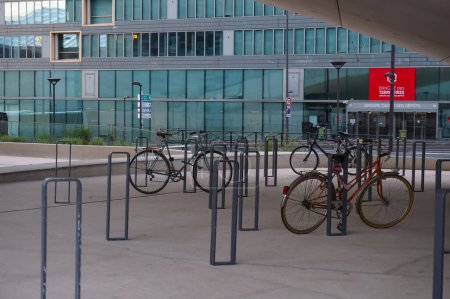 Foto de París, Francia - junio 2021 - Aparcamiento para bicicletas con cierres en forma de anillo bajo el arco de la sede del Grupo Le Monde, en la avenida Pierre Mendes-France, en el distrito financiero de Paris Rive Gauche - Imagen libre de derechos